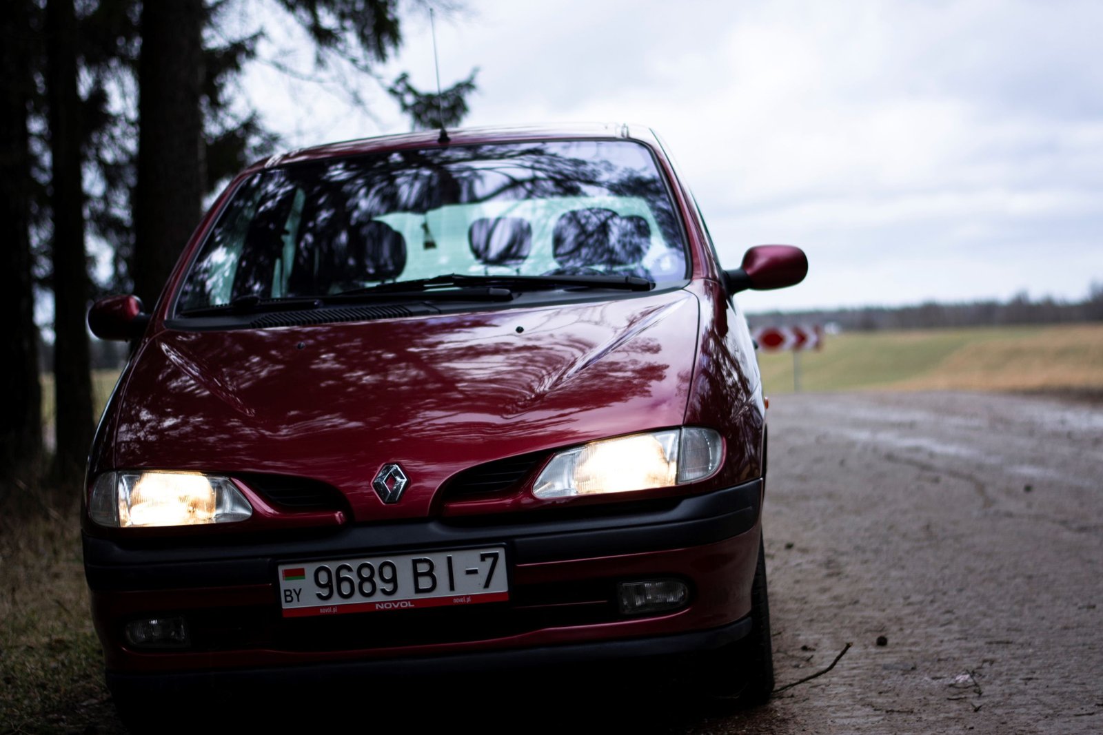 Automobiliste au téléphone près d'une voiture Renault, dépanneuse en arrière-plan